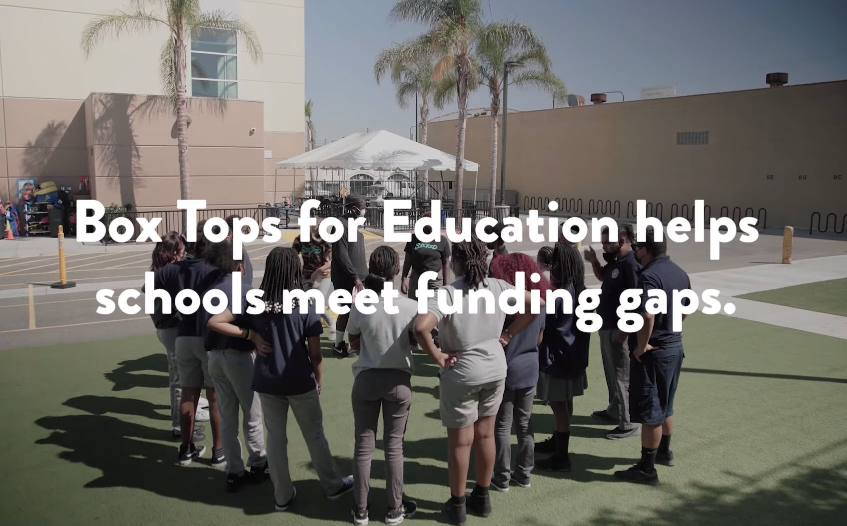 Kids in a circle outside with the words Box Tops for Education helps schools meet funding gaps. 